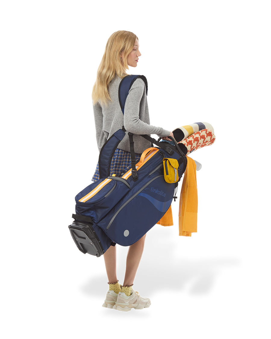 Woman golfer carrying the Atlantic Dawn Linkslite Explorer stand bag over one shoulder.