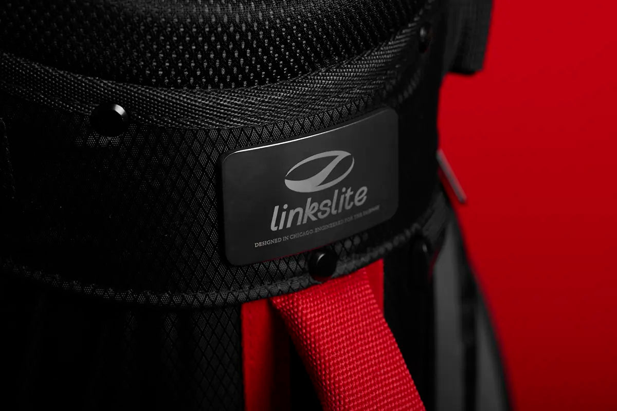 Close-up on the premium metal logo badge of Linkslite's The Explorer black stand bag.
